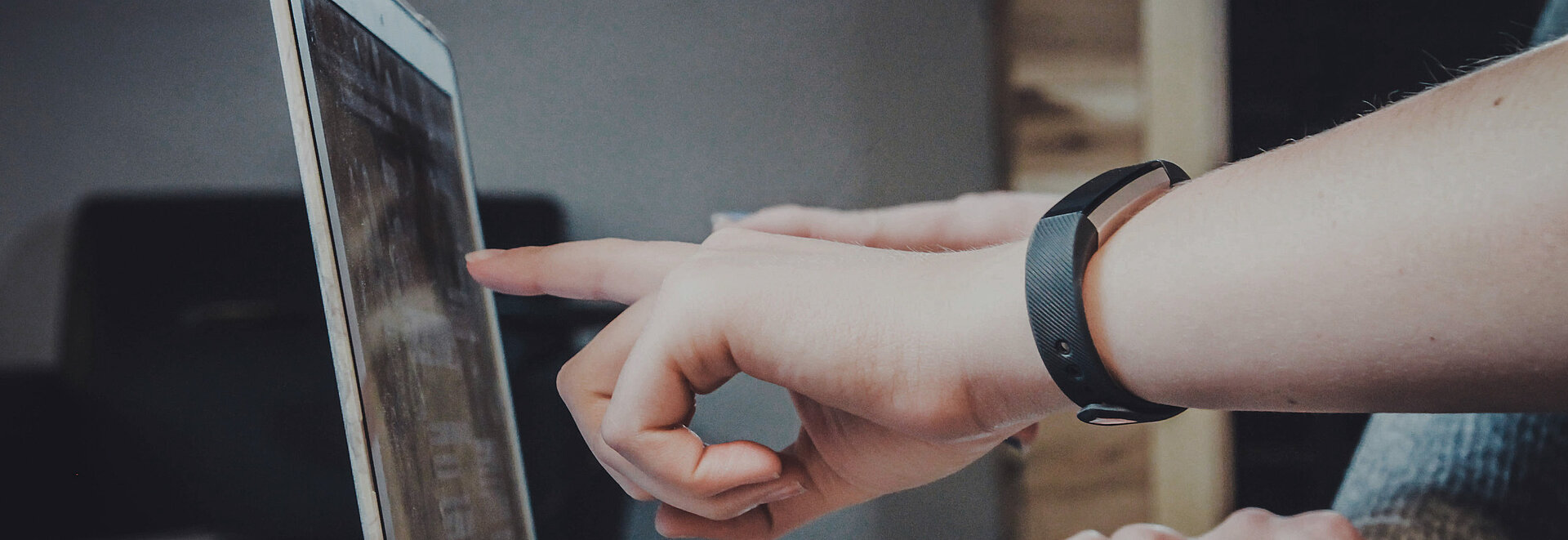 Eine Person zeigt auf einen Laptopbildschirm