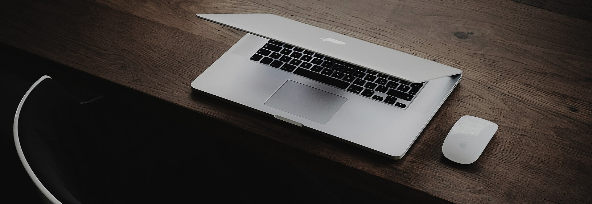 Ein Macbook steht auf einem Holz Schreibtisch