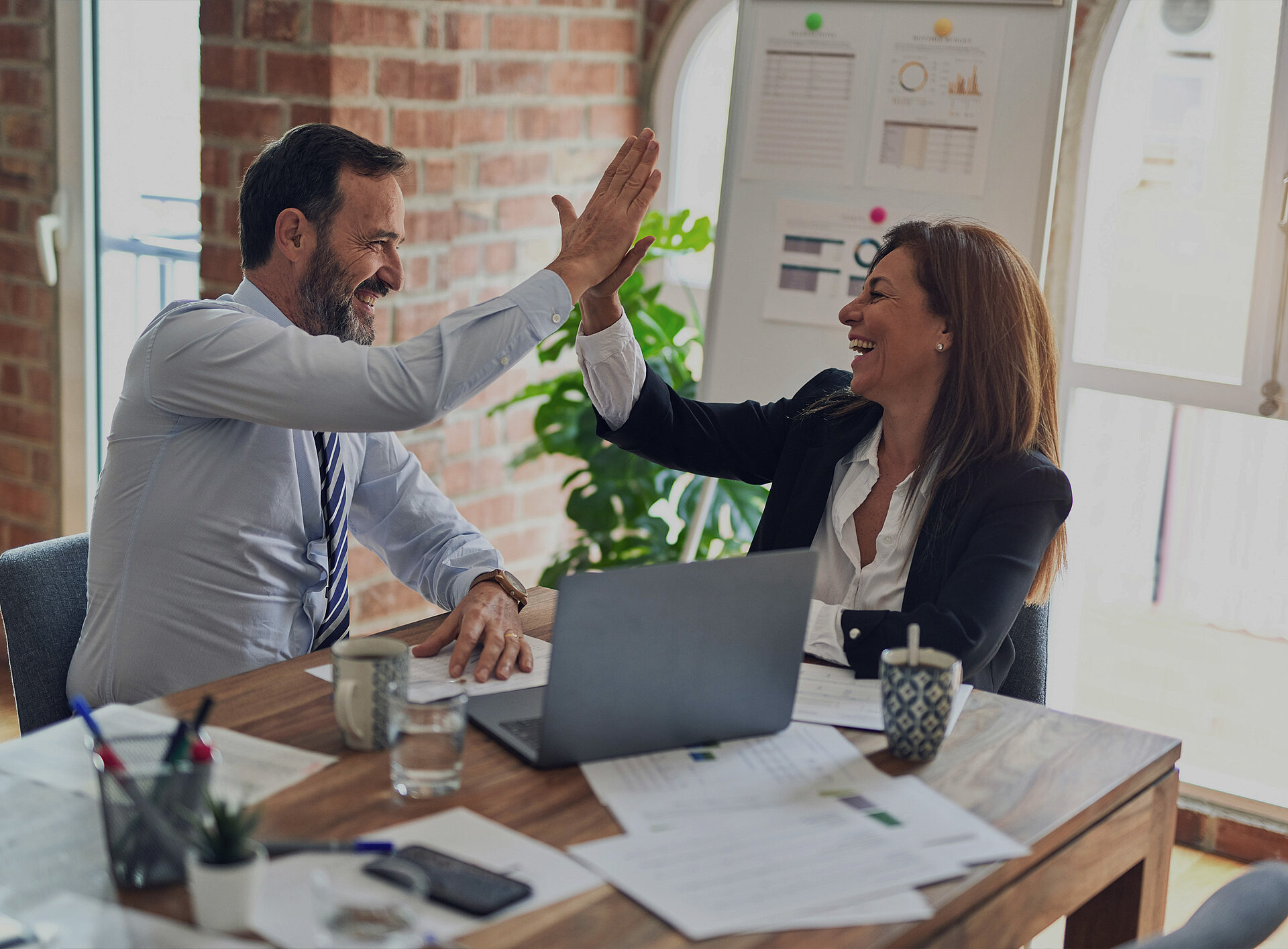 Zwei Personen geben sich ein "High Five"