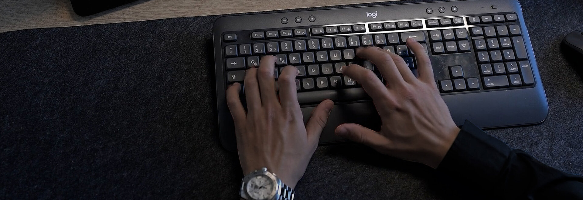 Nahaufnahme von Händen die auf eine Tastatur tippen