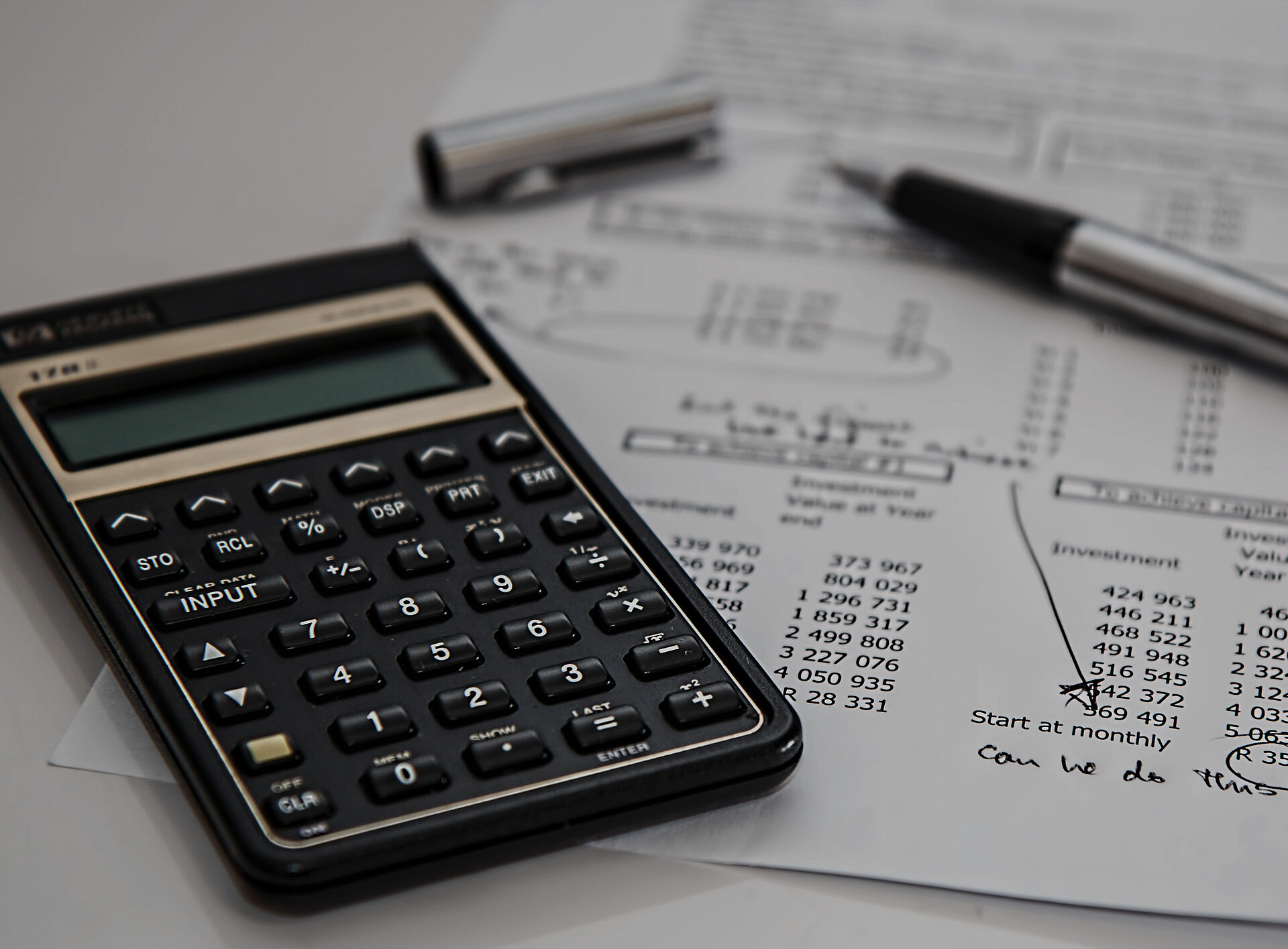 Ein Taschenrechner, Papier mit Notizen und ein Kugelschreiber