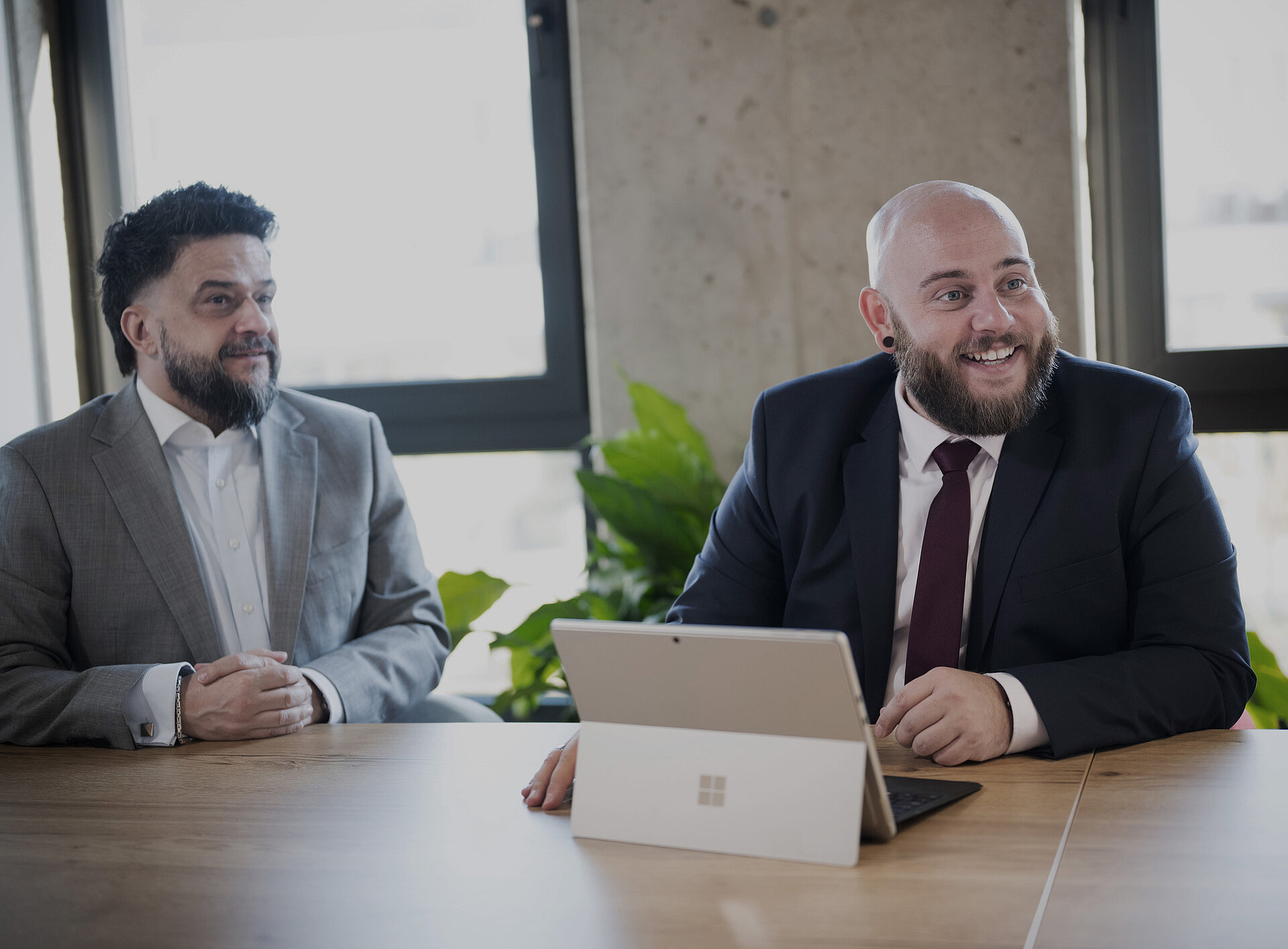 Zwei Personen beraten sich vor einem Laptop
